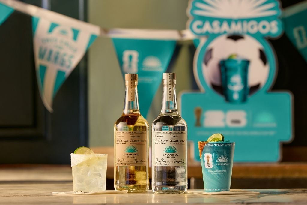 two bottles of alcohol next to a cup of ice